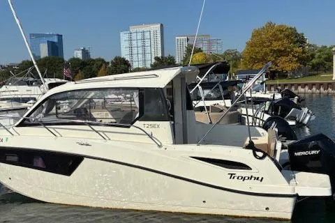 Slide: The Image of 2024 Bayliner Trophy T25 Explorer boat docked in a marina with city skyline. - 3