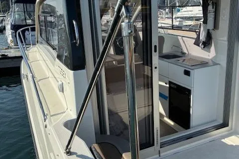 Slide: The Image of 2024 Bayliner Trophy T25 Explorer boat interior with kitchenette, docked at marina. - 5