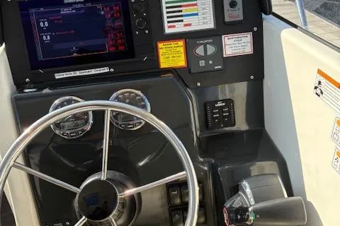 Slide: The Image of 2024 Bayliner Trophy T25 Explorer dashboard with steering wheel and control panel. - 9