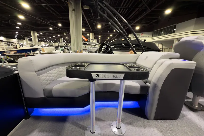 Slide: The Image of 2026 Godfrey Monaco 235 Split Bench boat interior with modern seating and table. - 17
