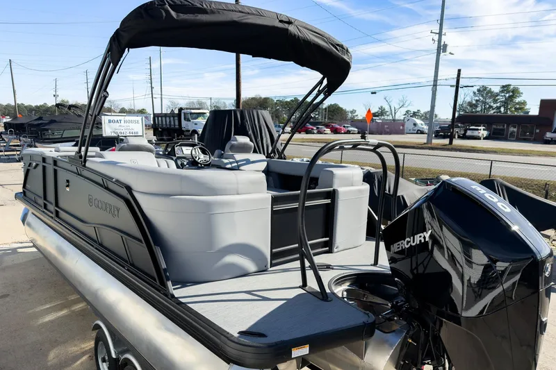 Slide: The Image of 2026 Godfrey Monaco 235 Split Bench pontoon boat with Mercury engine, docked outdoors. - 24