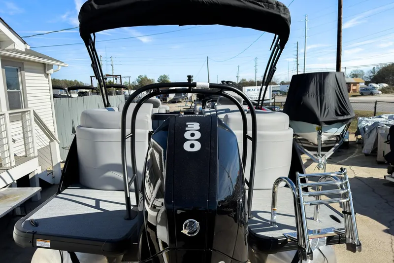 Slide: The Image of 2026 Godfrey Monaco 235 Split Bench boat with powerful engine, docked outdoors. - 30