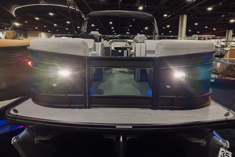 Slide: The Image of 2026 Godfrey Monaco 235 Split Bench pontoon boat with illuminated deck at indoor exhibition. - 4