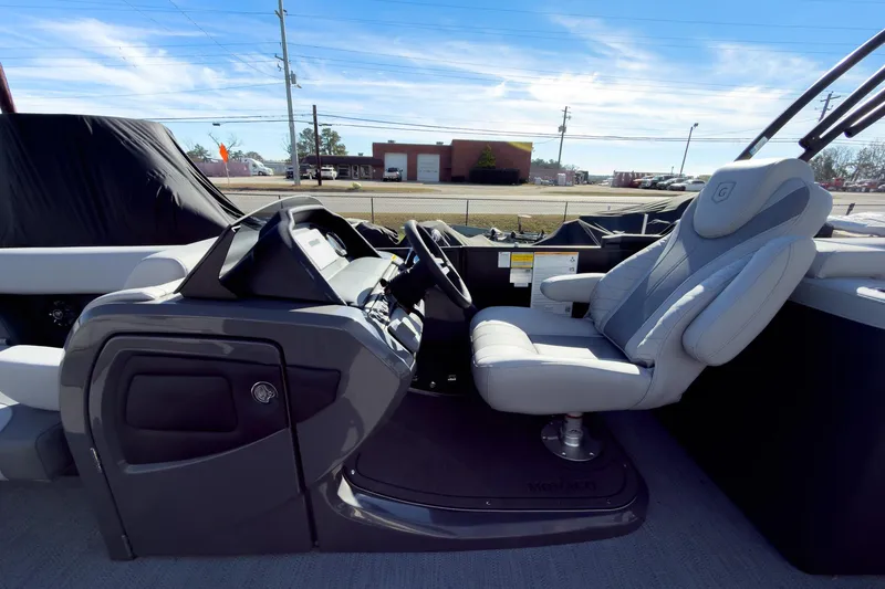 Slide: The Image of 2026 Godfrey Monaco 235 Split Bench boat interior with captain's chair and control panel. - 49