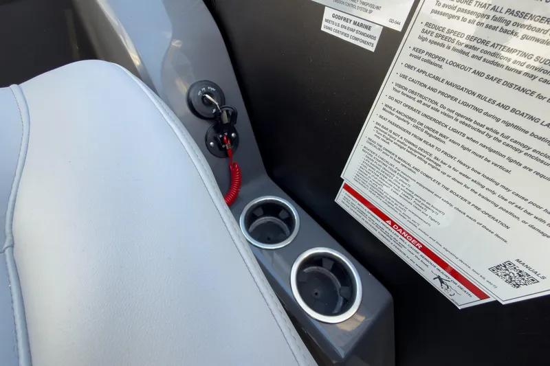 Slide: The Image of Interior of 2026 Godfrey Monaco 235 Split Bench with safety instructions and cup holders. - 57