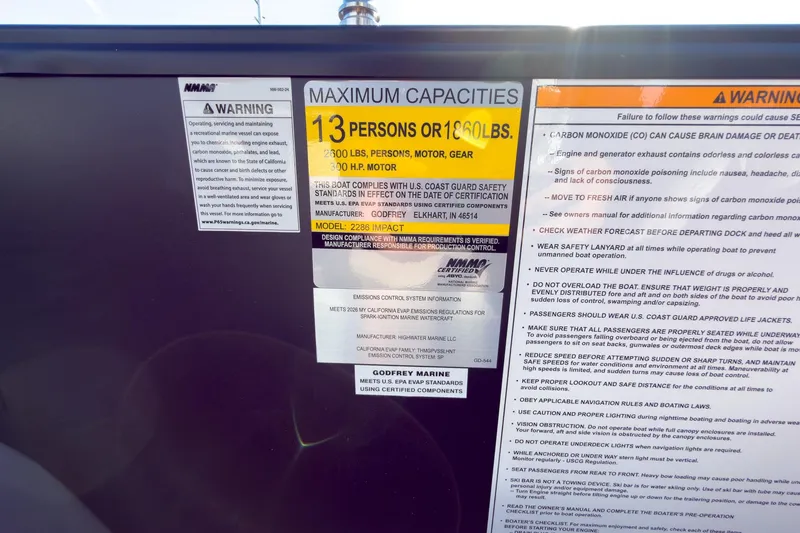 Slide: The Image of Warning labels on 2026 Godfrey Monaco 235 Split Bench boat, detailing safety and capacity information. - 58
