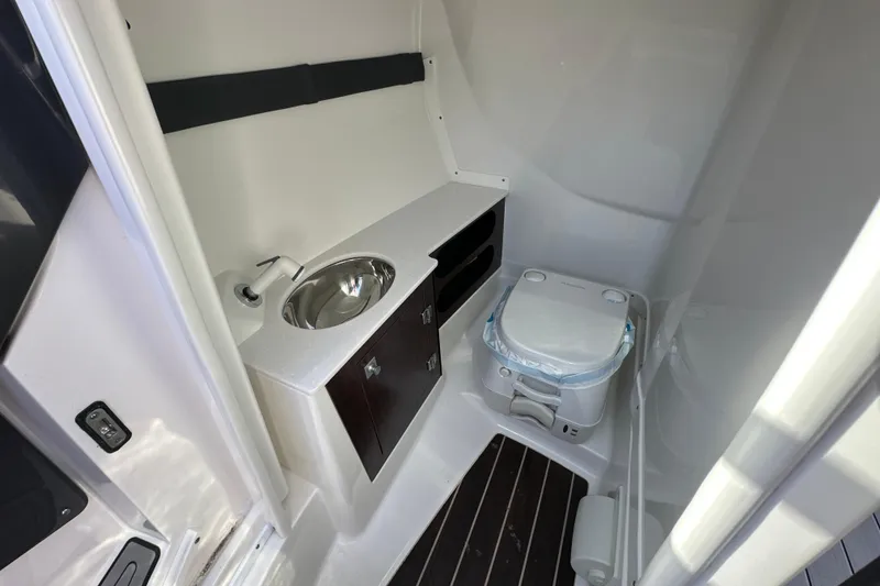 Slide: The Image of 2019 Monterey 278SS Super Sport boat interior with open storage compartment and steering wheel. - 35