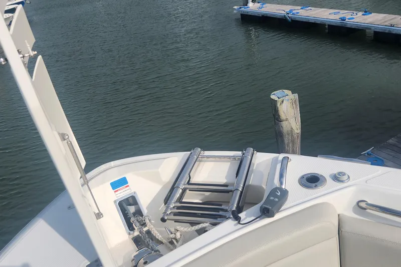 Slide: The Image of Boston Whaler 280 Vantage 2021 boat docked, featuring ladder and control panel. - 18