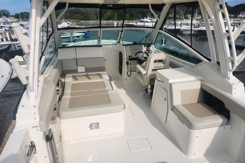 Slide: The Image of 2021 Boston Whaler 280 Vantage boat interior with seating and helm, docked at marina. - 5