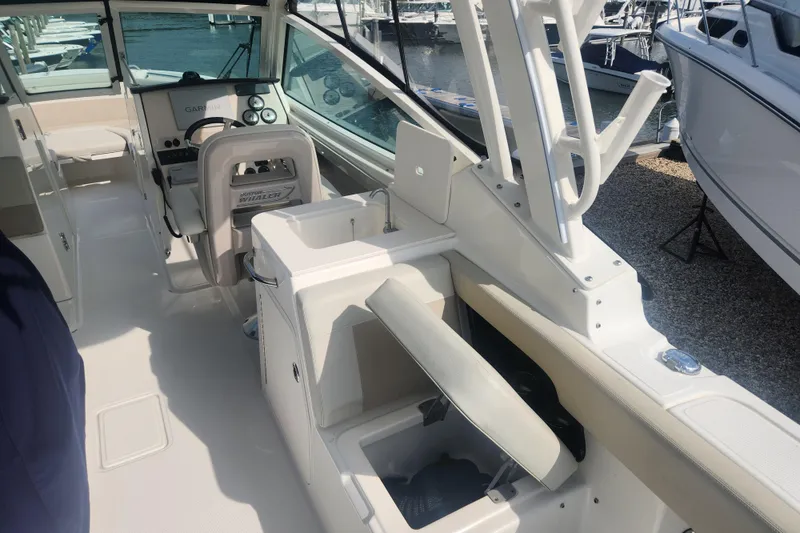 Slide: The Image of 2021 Boston Whaler 280 Vantage boat interior with helm, seating, and sink, docked at marina. - 6