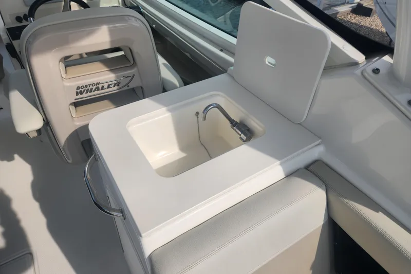 Slide: The Image of 2021 Boston Whaler 280 Vantage boat interior with sink and seating area. - 7