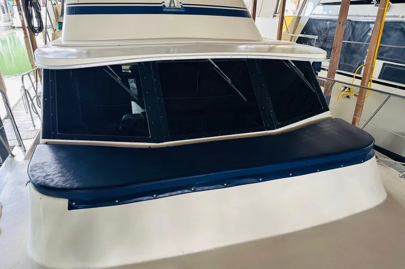 Slide: The Image of 1985 Bluewater 51 Coastal Cruiser boat with dark tinted windows and blue seating. - 10