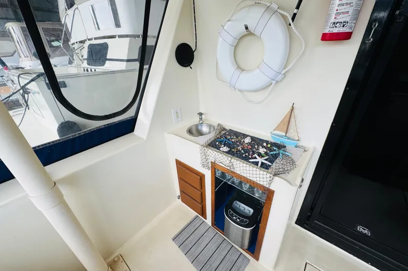 Slide: The Image of 1985 Bluewater 51 Coastal Cruiser interior with nautical decor, sink, and safety equipment. - 12