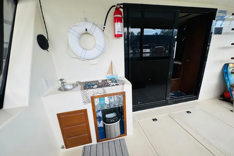 Slide: The Image of 1985 Bluewater 51 Coastal Cruiser interior with sink, life preserver, and sliding door. - 14