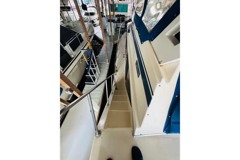 Slide: The Image of 1985 Bluewater 51 Coastal Cruiser docked, showing side deck and railing. - 16