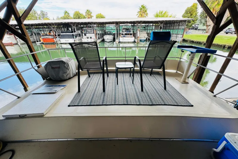 Slide: The Image of 1985 Bluewater 51 Coastal Cruiser deck with chairs, table, and marina view. - 18