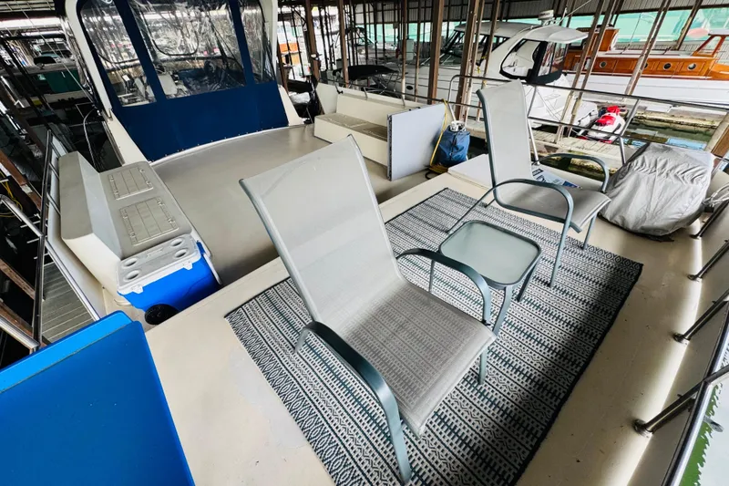 Slide: The Image of 1985 Bluewater 51 Coastal Cruiser deck with chairs and table on patterned rug. - 20
