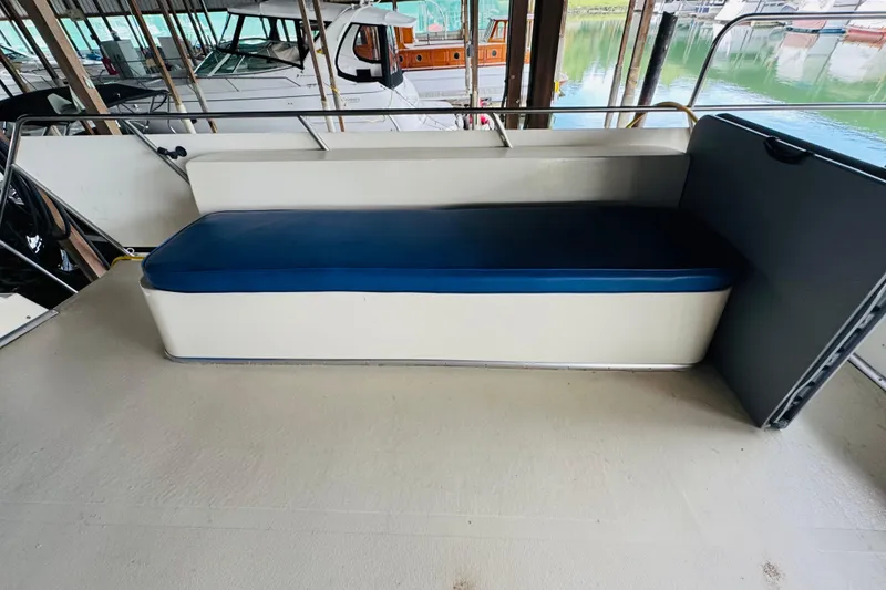 Slide: The Image of 1985 Bluewater 51 Coastal Cruiser boat seating area with blue cushion in marina setting. - 23