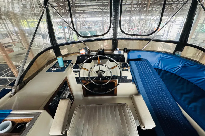 Slide: The Image of Interior view of 1985 Bluewater 51 Coastal Cruiser helm with steering wheel and seating. - 25