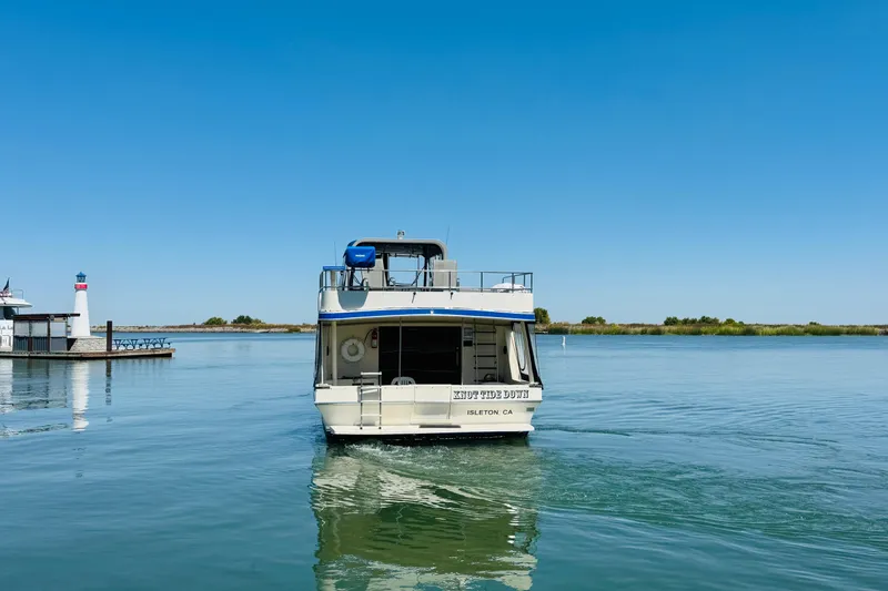 Slide: The Image of 1985 Bluewater 51 Coastal Cruiser on calm water near a lighthouse. - 3