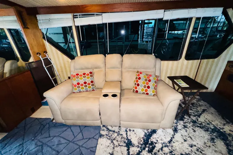 Slide: The Image of Interior of 1985 Bluewater 51 Coastal Cruiser with beige recliner and colorful pillows. - 31