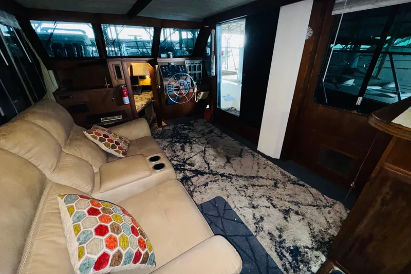 Slide: The Image of Interior of 1985 Bluewater 51 Coastal Cruiser with beige seating and colorful cushions. - 32
