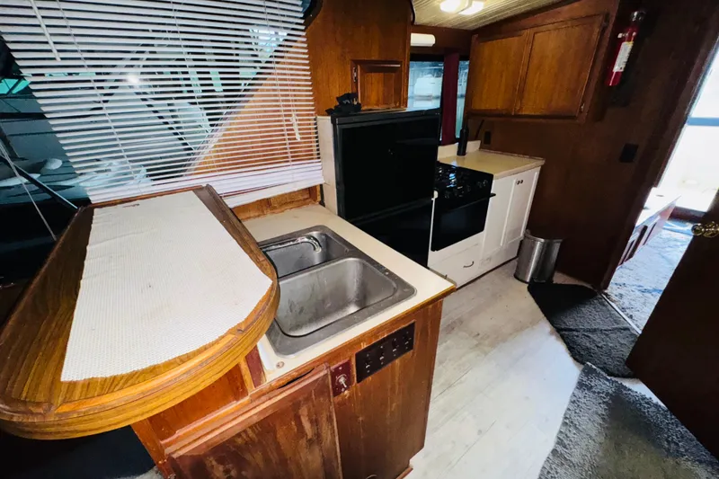 Slide: The Image of Interior of 1985 Bluewater 51 Coastal Cruiser with kitchen sink, stove, and wooden cabinetry. - 33