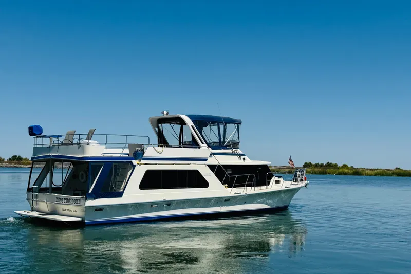 Slide: The Image of 1985 Bluewater 51 Coastal Cruiser yacht on calm water under clear blue sky. - 4