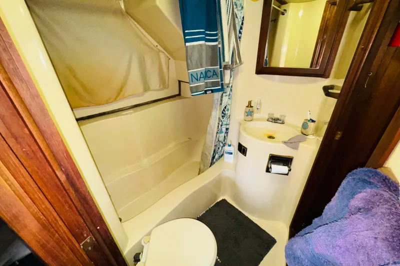Slide: The Image of 1985 Bluewater 51 Coastal Cruiser bathroom with shower, sink, and wooden accents. - 41