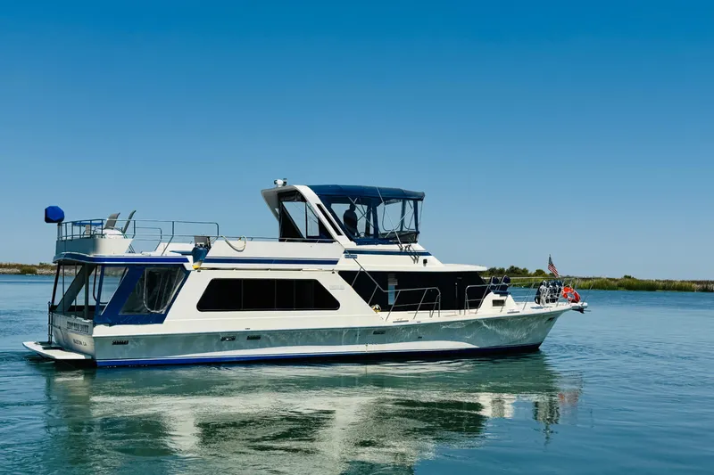 Slide: The Image of 1985 Bluewater 51 Coastal Cruiser yacht on calm water under clear blue sky. - 5
