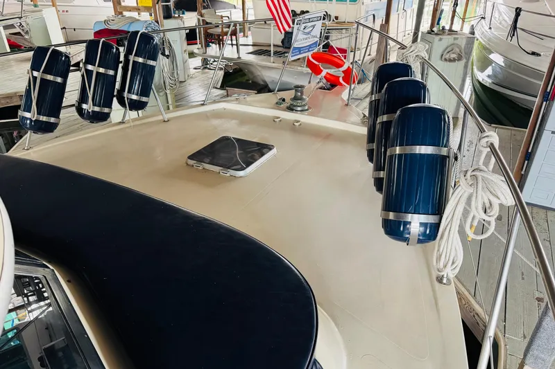 Slide: The Image of 1985 Bluewater 51 Coastal Cruiser yacht deck with fenders and ropes in a marina. - 7
