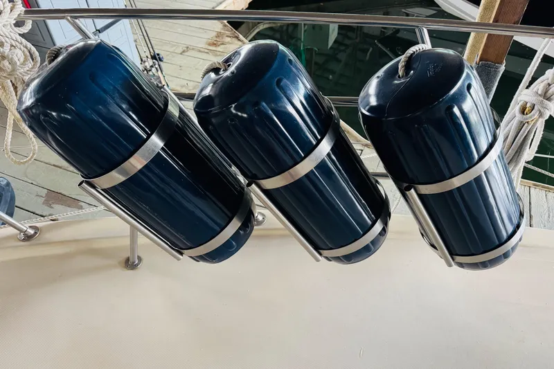 Slide: The Image of Bluewater 51 Coastal Cruiser 1985 with three blue boat fenders secured on deck. - 8