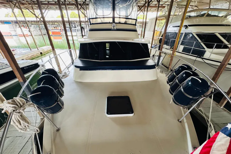 Slide: The Image of 1985 Bluewater 51 Coastal Cruiser docked in a marina, featuring spacious deck and seating. - 9