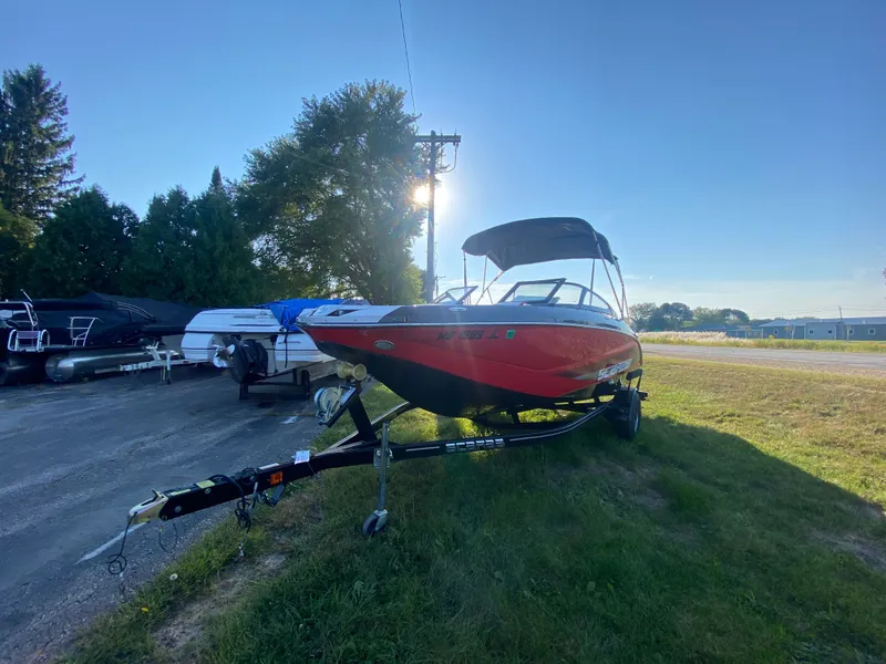 Slide: The Image of 2016 Scarab 215 HO/IMPULSE boat on trailer outdoors. - 1