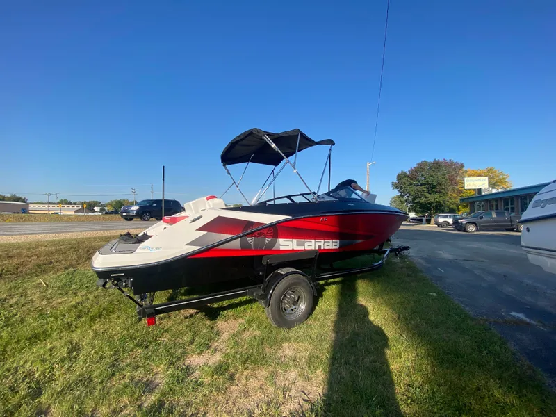 Slide: The Image of 2016 Scarab 215 HO/IMPULSE boat on trailer outdoors. - 2