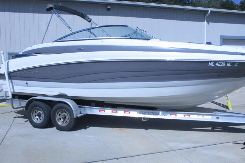 Slide: The Image of 2017 Crownline 255 SS boat on trailer, white and gray exterior, parked outdoors. - 2