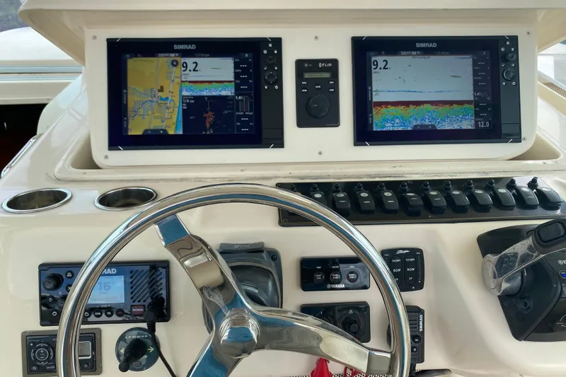Slide: The Image of Control panel of a 2012 Grady-White Express 360 boat with navigation screens and steering wheel. - 10