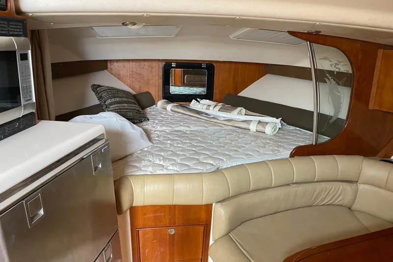 Slide: The Image of 2012 Grady-White Express 360 cabin interior with bed, seating, and kitchenette. - 13