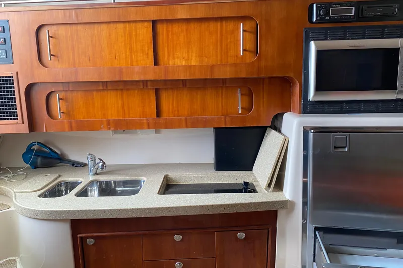 Slide: The Image of 2012 Grady-White Express 360 boat kitchen with wood cabinets, sink, and appliances. - 18