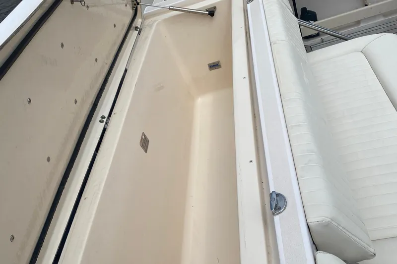 Slide: The Image of Open storage compartment on 2012 Grady-White Express 360 boat, next to white cushioned seating. - 24
