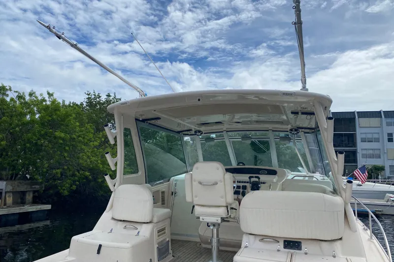 Slide: The Image of 2012 Grady-White Express 360 boat with fishing rods, docked near trees and buildings. - 4