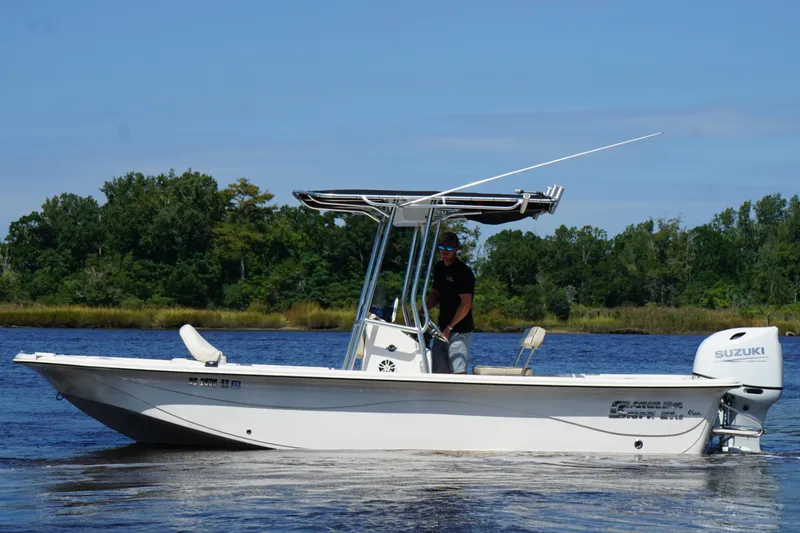 Slide: The Image of 2023 Carolina Skiff 21 LS boat on water, featuring Suzuki outboard motor. - 1