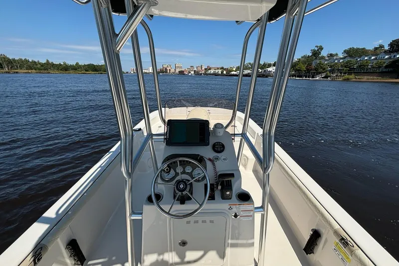 Slide: The Image of 2023 Carolina Skiff 21 LS boat console with steering wheel on a calm river. - 13