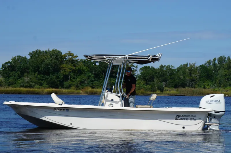 Slide: The Image of 2023 Carolina Skiff 21 LS boat on water, featuring Suzuki outboard motor. - 23