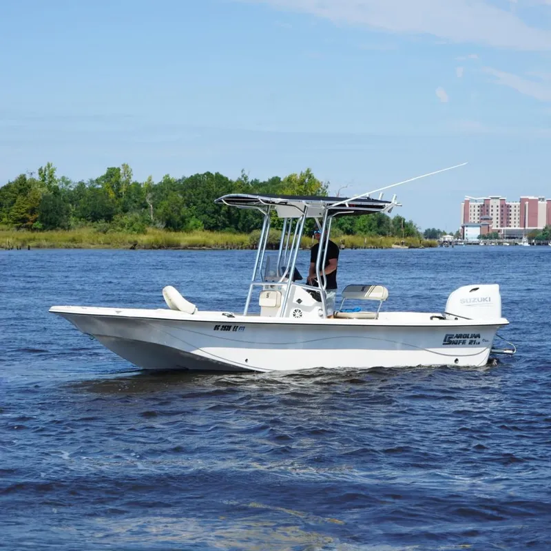 Slide: The Image of 2023 Carolina Skiff 21 LS boat on water, featuring Suzuki outboard motor. - 3