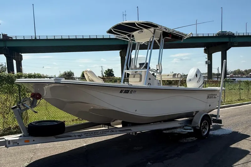 Slide: The Image of 2023 Carolina Skiff 21 LS boat on trailer under a bridge, sunny day. - 5