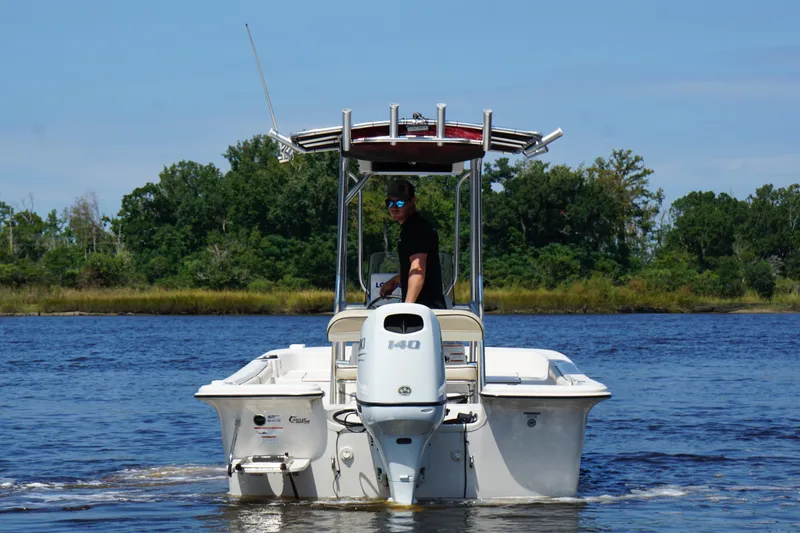 Slide: The Image of 2023 Carolina Skiff 21 LS boat cruising on a scenic river with lush greenery. - 6