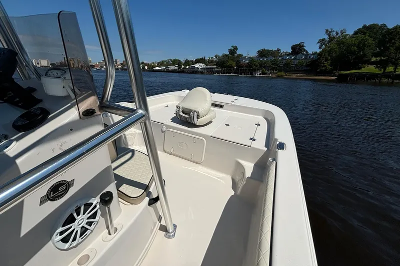 Slide: The Image of 2023 Carolina Skiff 21 LS boat on calm river, featuring sleek interior and scenic background. - 8