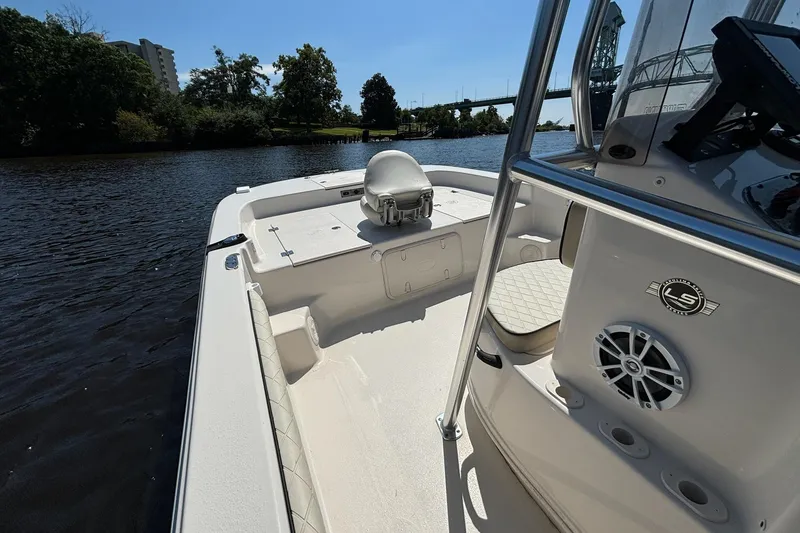 Slide: The Image of 2023 Carolina Skiff 21 LS boat on a calm river, featuring spacious deck and seating. - 9