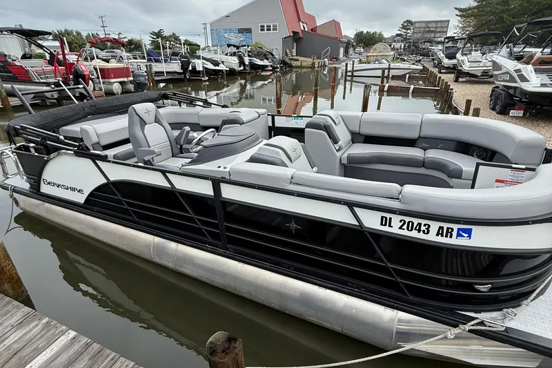 Slide: The Image of 2026 Berkshire 23CL STS pontoon boat parked on a trailer in a lot. - 1